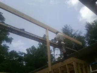 Carpenter setting a ridge beam over a new addition frame — Ice Dam Removal by Roofing Brothers in Westley