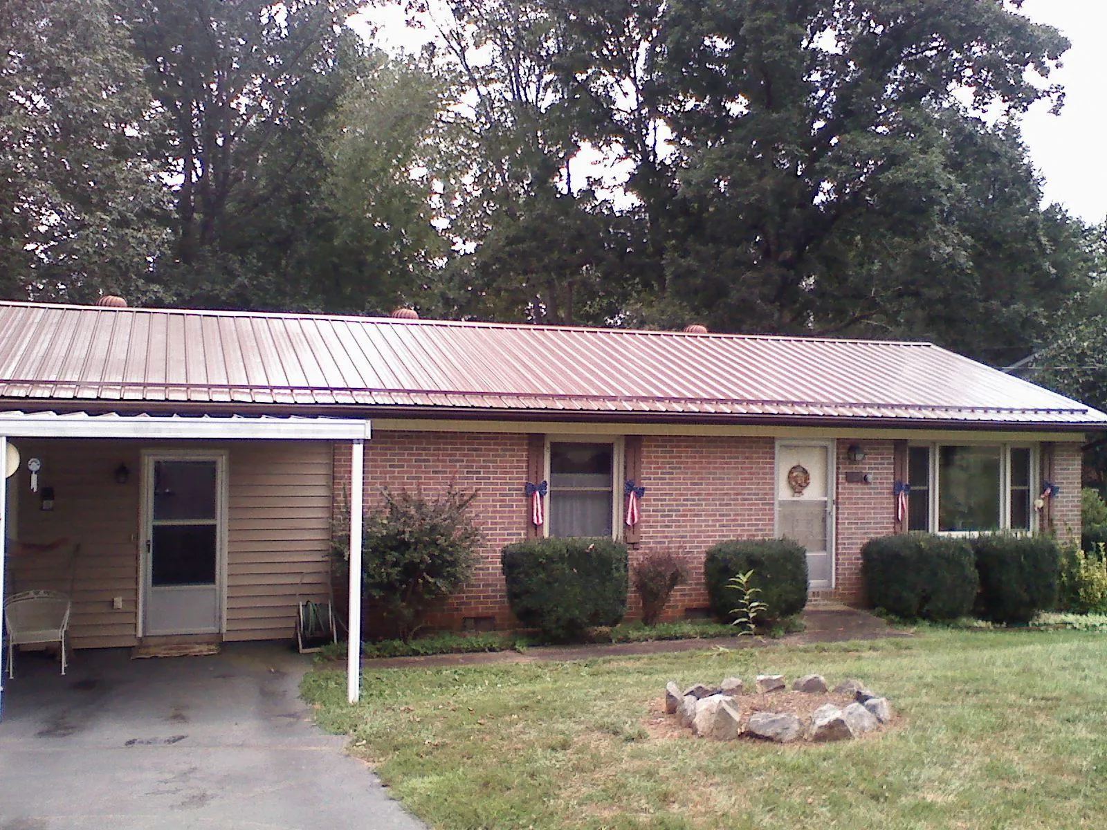 Bronze metal roof and carport on a brick ranch home — Roof Repair work by our crew in Westley